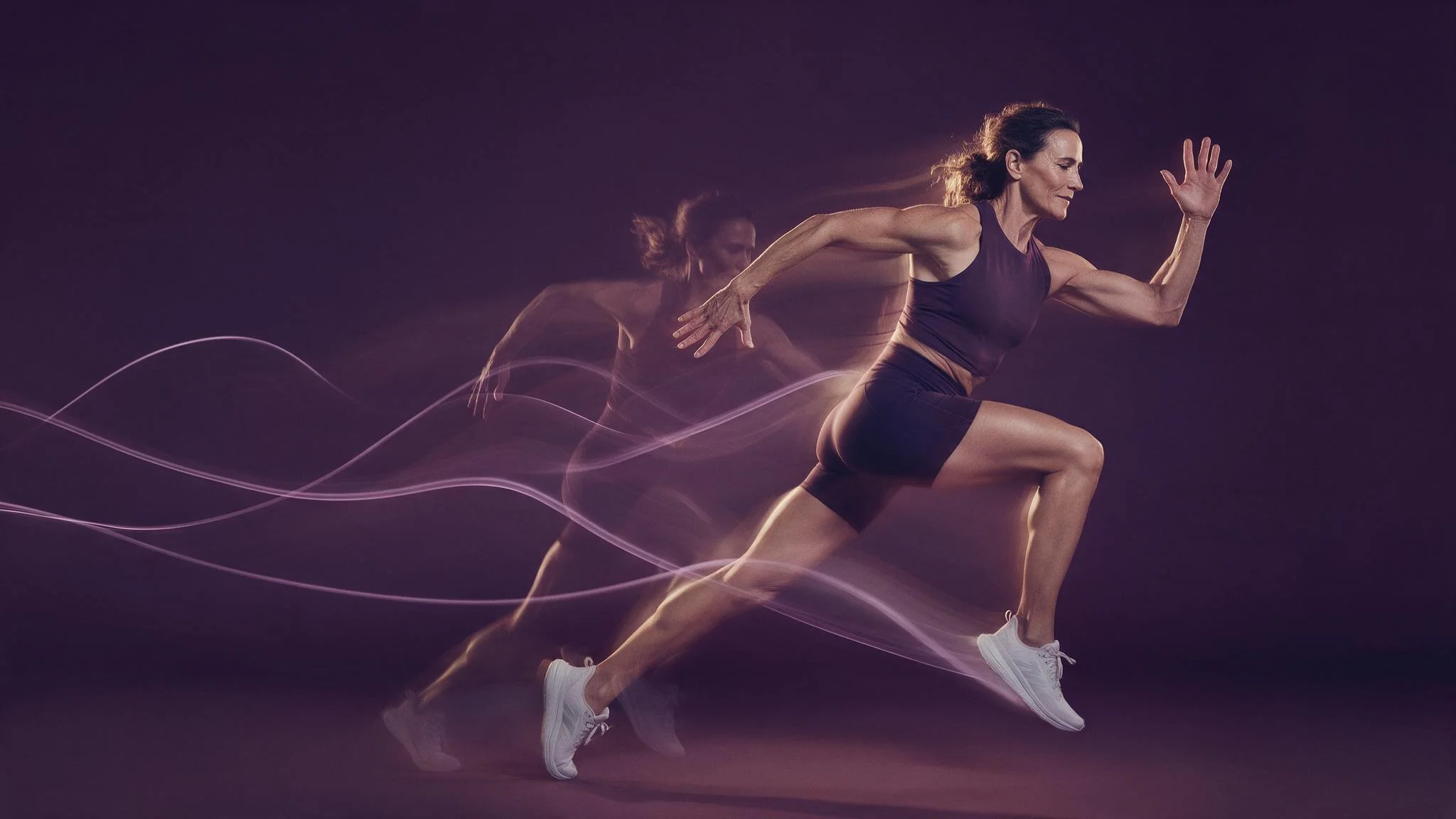 A woman at a full sprint, a translucent echo of an earlier stride trailing behind