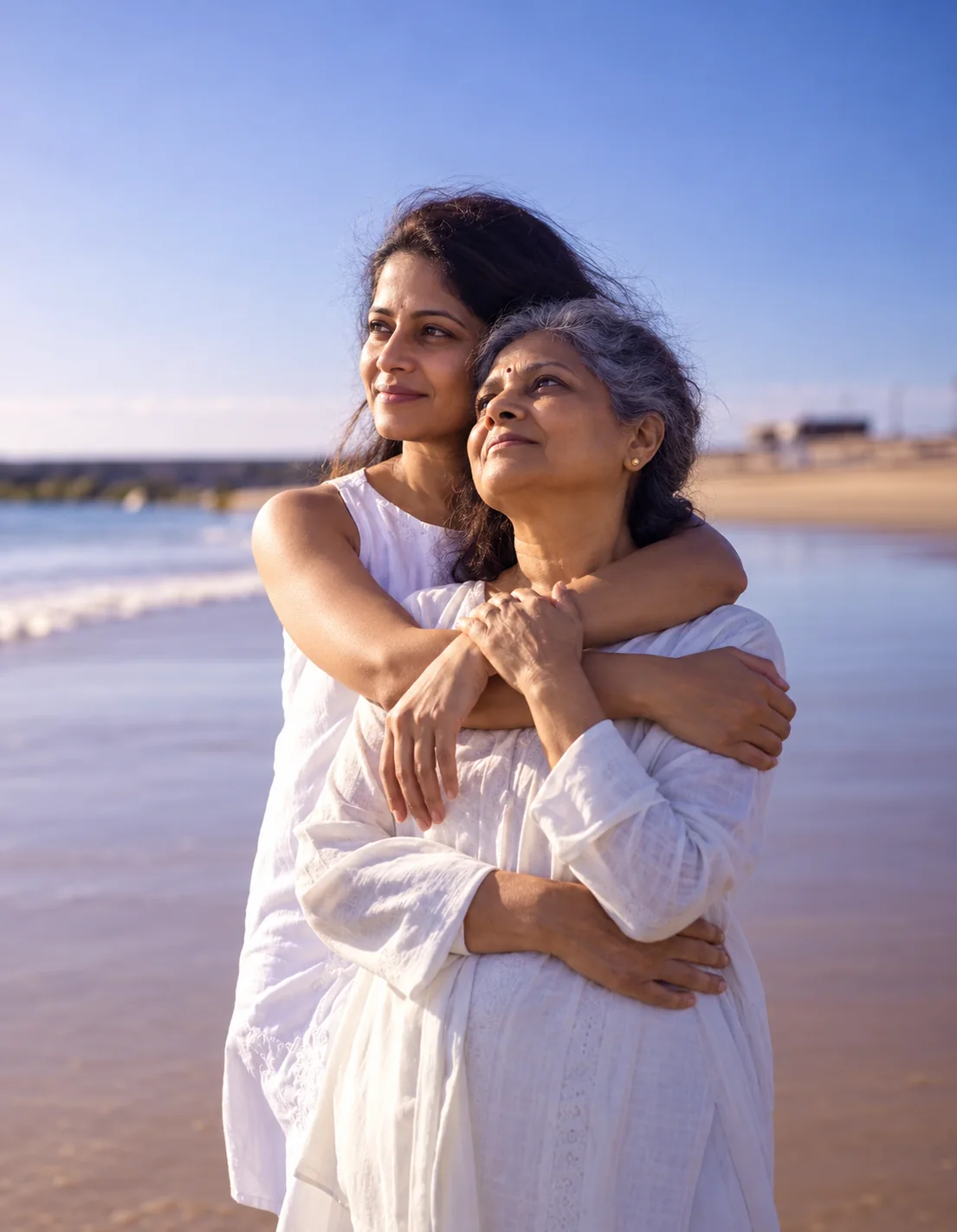 A daughter embracing her mother on a beach